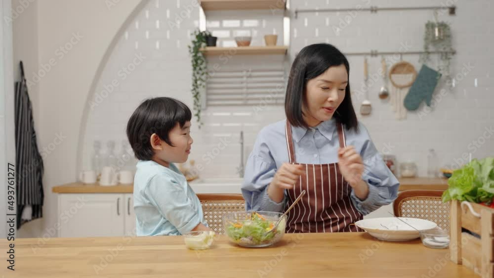 Asian happy family cooking in kitchen room at house.Mother is feeding her son salad to learn how to eat vegetables for health benefits.Family relationship
Asian happy family cooking in kitchen room at house.Mother is feeding her son salad to learn how to eat vegetables for health benefits.Family relationship