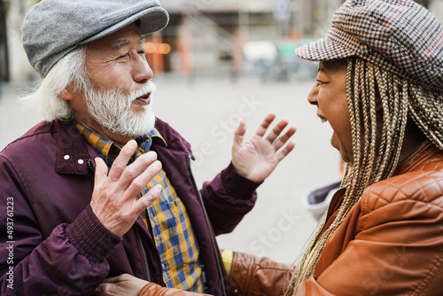 Multiracial happy senior friends having fun greeting each other outdoor - Soft focus on woman mouth
