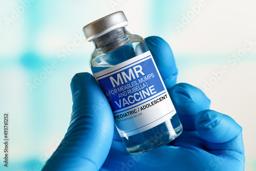 Doctor with vial of the doses vaccine for MMR Measless, Mumps and Rubella diseases. Medicine and health care concept. Vaccination for booster shot for MMR Measless, Mumps and Rubella diseases photo