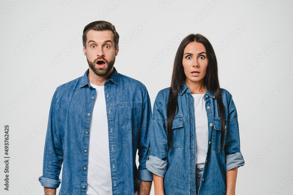 Total shock. Impressed surprised caucasian young couple spouses girlfriend and boyfriend with open mouth feeling frustrated about sale discount offer isolated in white background