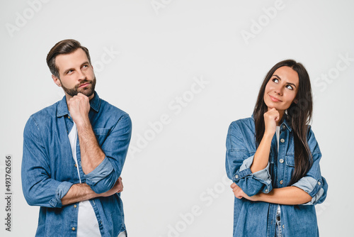 Thoughtful pensive caucasian young couple looking upwards for free space copyspace, thinking new ideas, planning for future together isolated in white background photo