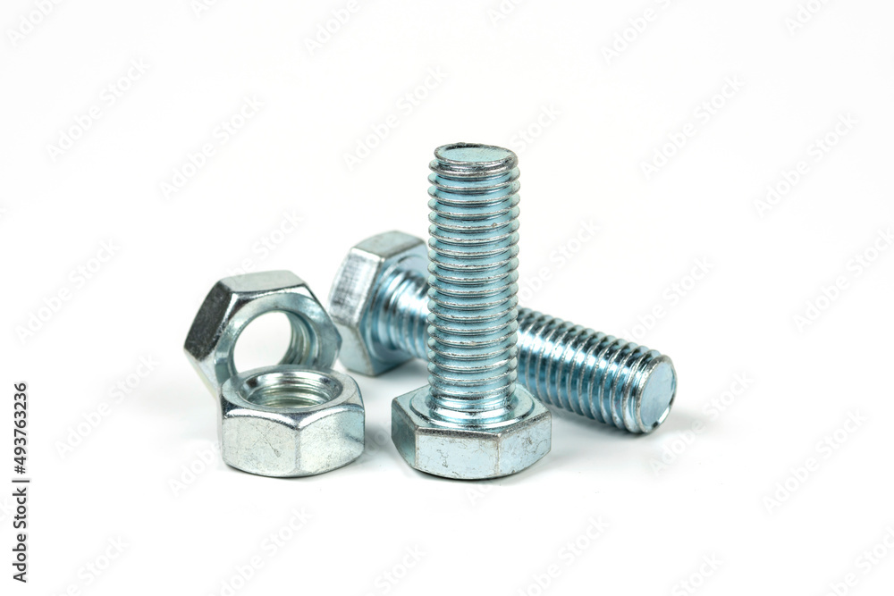 Several silver metal mounting bolts with nuts on a white background. Close-up Several silver metal mounting bolts with nuts on a white background. Close-up