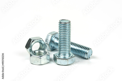 Fototapeta Naklejka Na Ścianę i Meble -  Several silver metal mounting bolts with nuts on a white background. Close-up