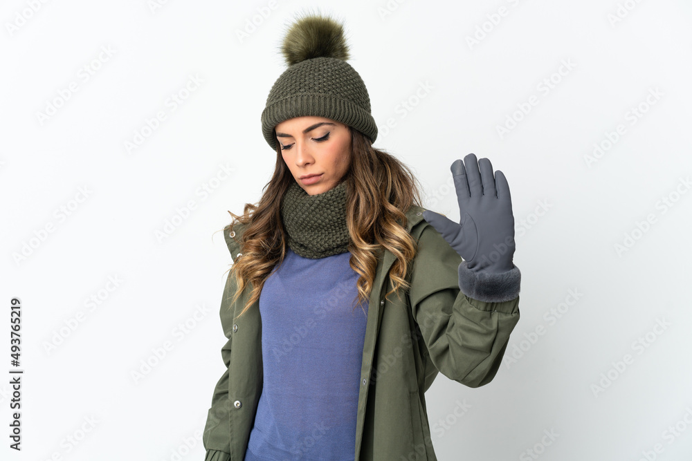 Young girl with winter hat isolated on white background making stop gesture and disappointed Young girl with winter hat isolated on white background making stop gesture and disappointed