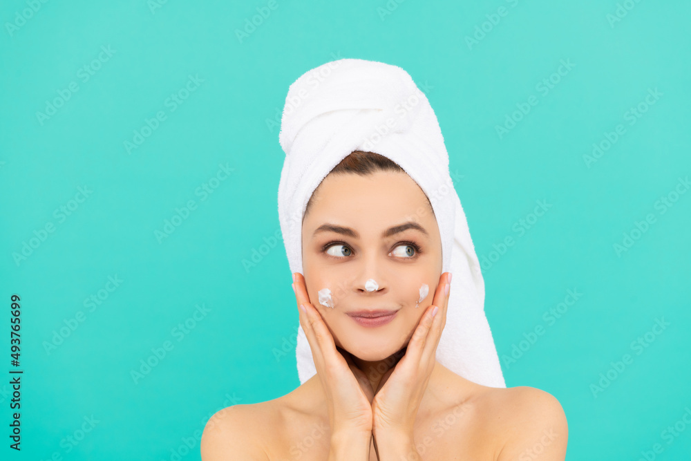 cheerful young lady apply face cream on blue background cheerful young lady apply face cream on blue background