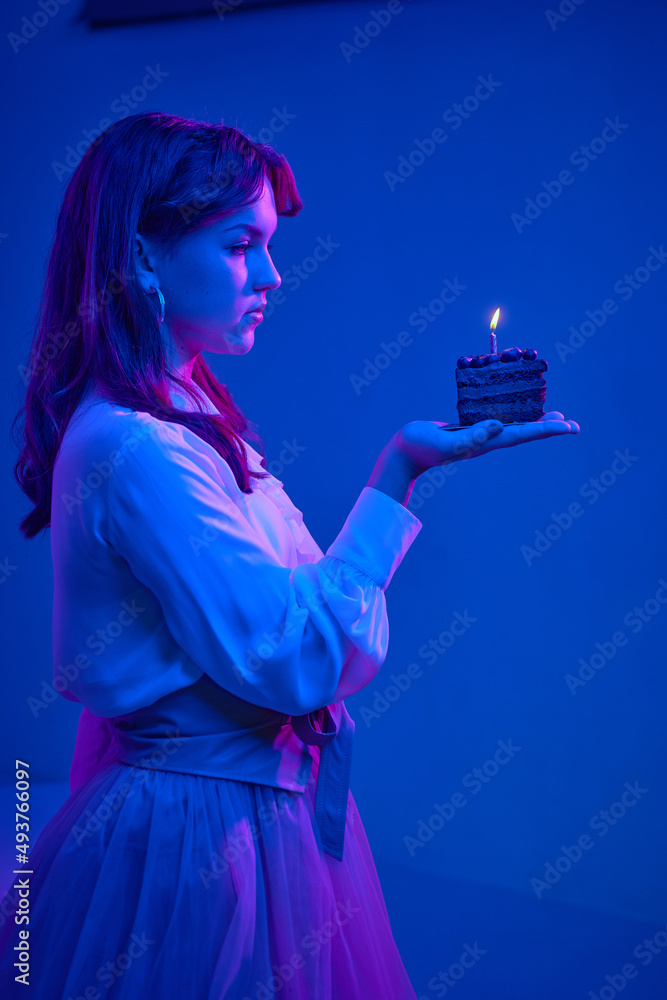Charming girl blows out candles on a birthday cake. The birthday girl