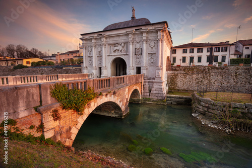 Treviso, Italy. Cityscape image of Treviso, Italy with gate to old city at sunset. photo