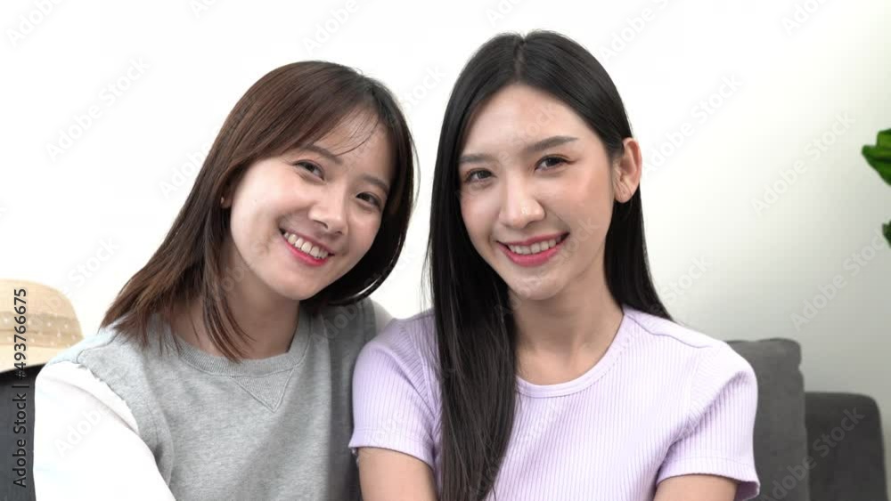 Beautiful smiling confident young asian ethnic woman pretty face looking at camera posing with friend at home in living room or office, Smiling close up front portrait Beautiful smiling confident young asian ethnic woman pretty face looking at camera posing with friend at home in living room or office, Smiling close up front portrait