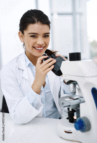 Ive always been curious about the world. Shot of a young scientist using a microscope in a lab.