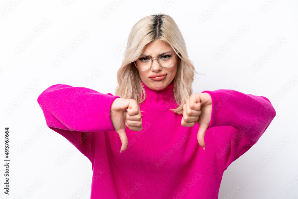 Young Russian woman isolated on white background showing thumb down with two hands Young Russian woman isolated on white background showing thumb down with two hands