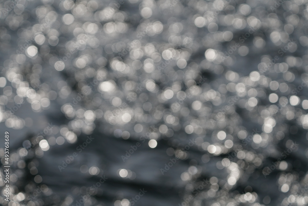 Fließendes Wasser in einem Fluss und mit Sonnenlicht, welches sich im Wasser spiegelt und reflektiert Fließendes Wasser in einem Fluss und mit Sonnenlicht, welches sich im Wasser spiegelt und reflektiert