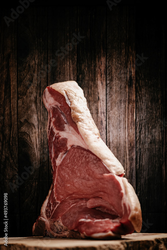 Fiorentina. Standing rib beef roast raw on a wooden background photo