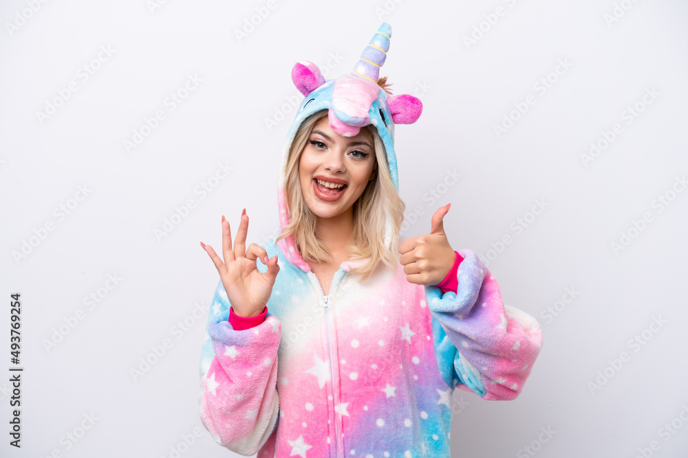 Young Russian woman with unicorn pajamas isolated on white background showing ok sign and thumb up gesture Young Russian woman with unicorn pajamas isolated on white background showing ok sign and thumb up gesture