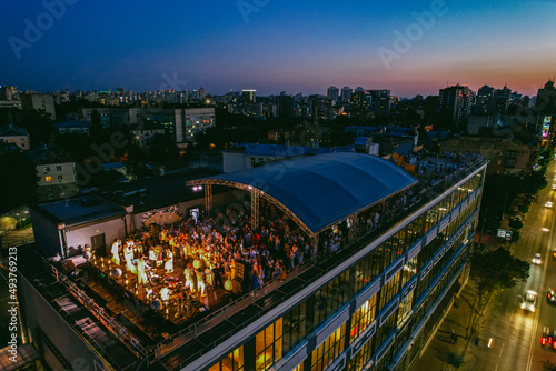 Fotografie Aerial view of people enjoying outdoor party on the rooftop at night