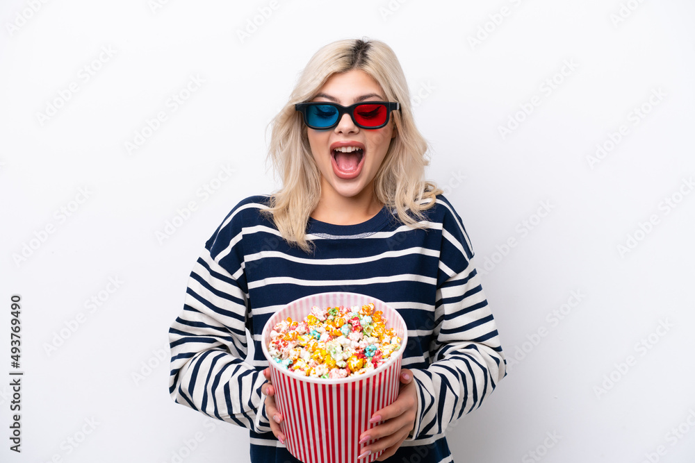 Young Russian woman isolated on white background with 3d glasses and holding a big bucket of popcorns