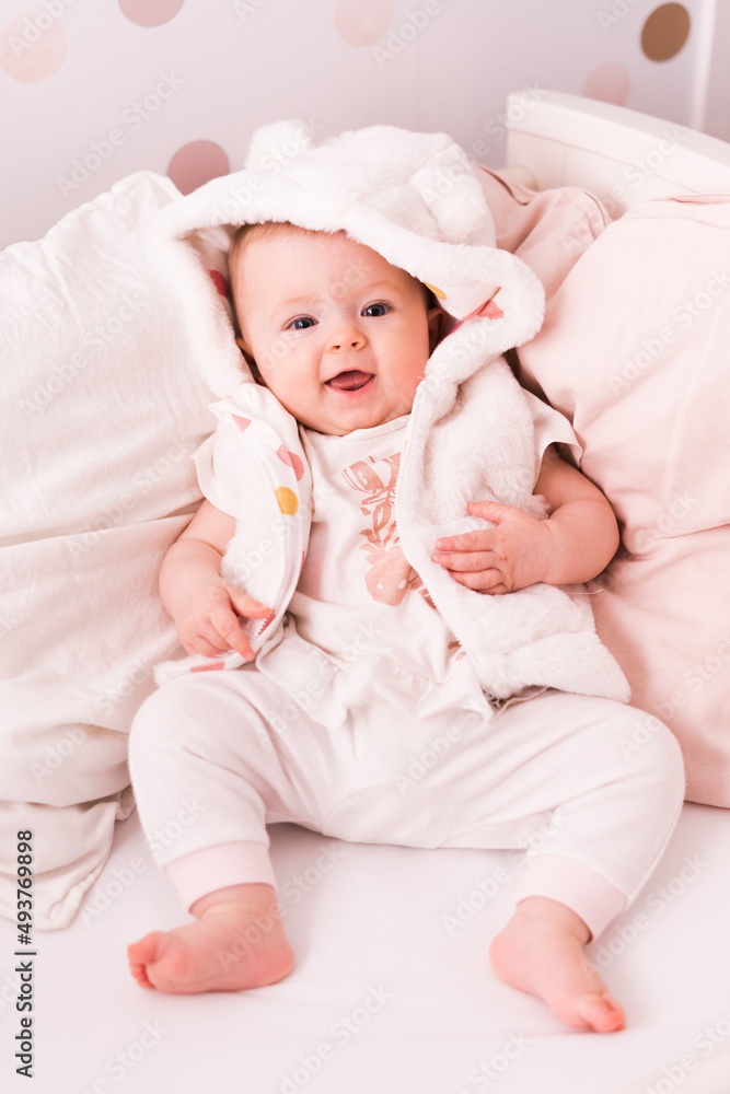 Baby girl, 5 month old, laying in bed, portrait of a toddler Baby girl, 5 month old, laying in bed, portrait of a toddler