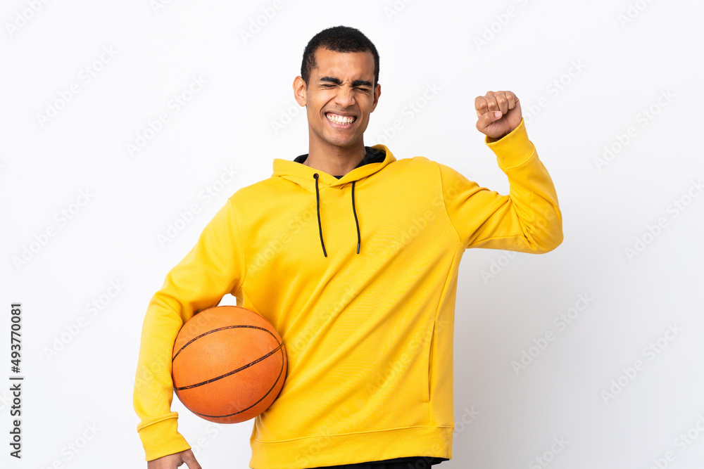 African American man over isolated white background playing basketball and proud of himself