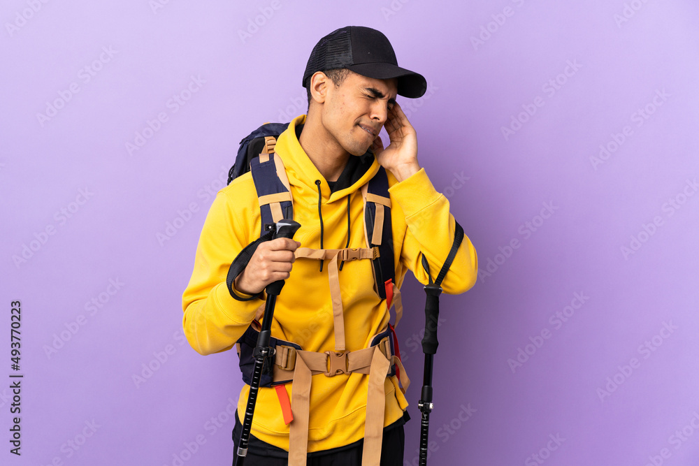 African American man with backpack and trekking poles over isolated background with headache African American man with backpack and trekking poles over isolated background with headache