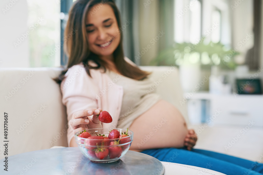 Snacking healthy. Shot of a pregnant woman snacking on strawberries. Snacking healthy. Shot of a pregnant woman snacking on strawberries.