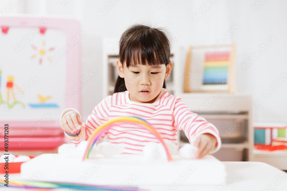 young girl making rainbow craft using pipe cleaner at home young girl making rainbow craft using pipe cleaner at home