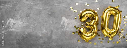 Yellow foil balloon number, number thirty on a concrete background. 30th birthday card. Anniversary concept. for anniversary, birthday, new year celebration. banner photo