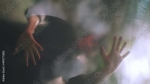 Young beautiful woman posing behind translucent material.