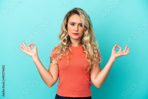 Young Brazilian woman isolated on blue background in zen pose