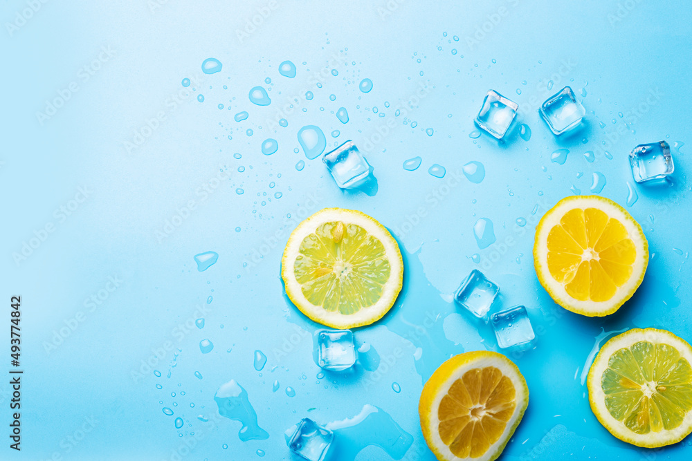 juicy fresh lemon slices and ice cubes on a blue background. Top view, flat lay