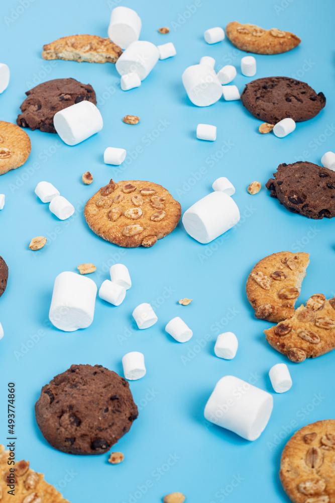 Background with white marshmallow and cookies on a blue background. Background with white marshmallow and cookies on a blue background.