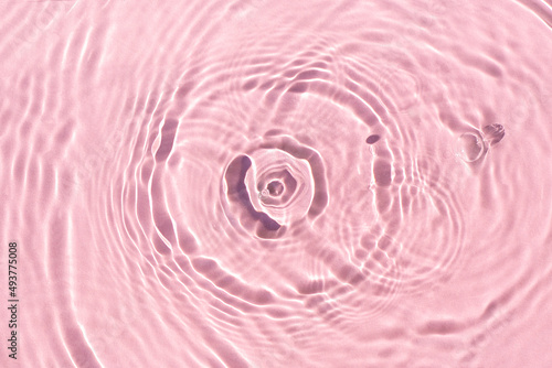 Splashes on pink water under sunlight. Top view  flat lay