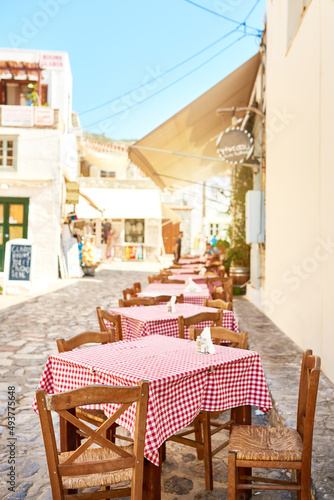 Ready to serve lunch. Shot of a group of empty tables and chairs packed outside a restaurant during the day. photo