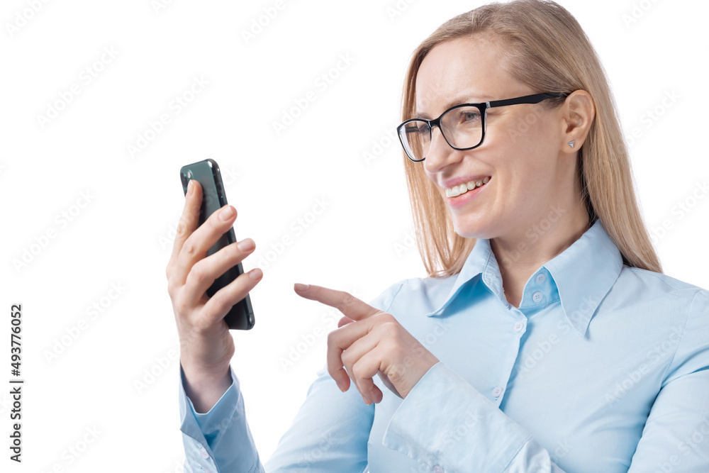 Business woman in eyeglasses and blue shirt using modern smartphone over white studio background. Successful mature blonde working on gadget indoors. Business woman in eyeglasses and blue shirt using modern smartphone over white studio background. Successful mature blonde working on gadget indoors.