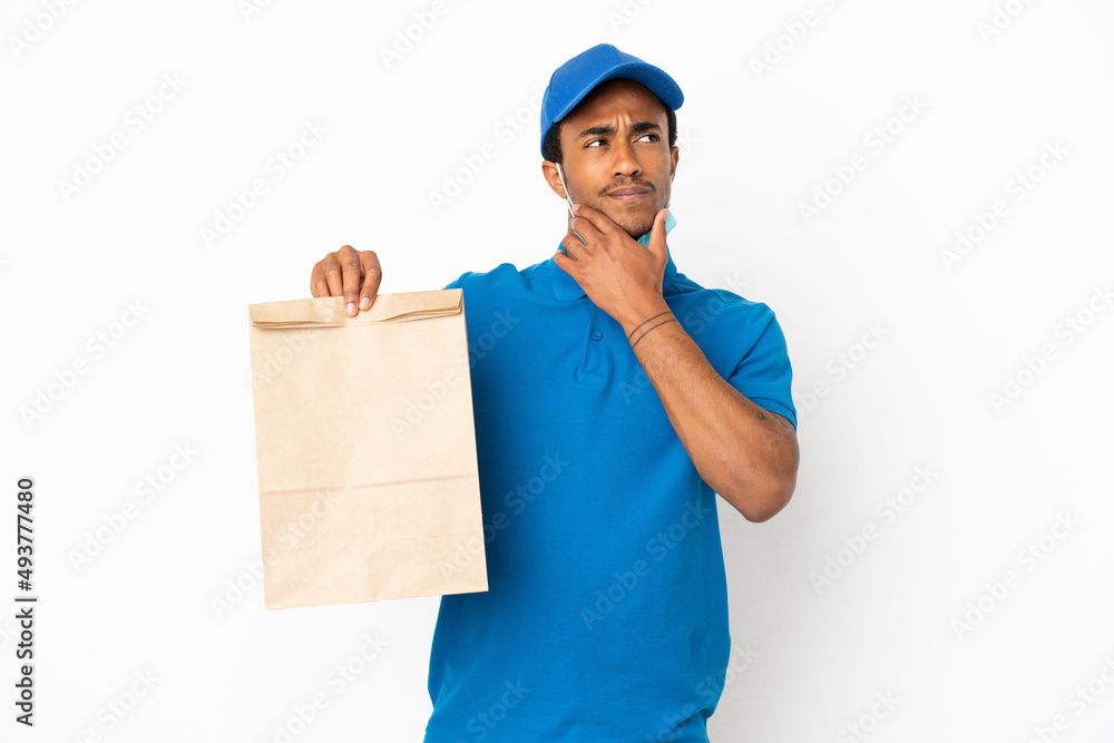 African American man taking a bag of takeaway food isolated on white background having doubts African American man taking a bag of takeaway food isolated on white background having doubts