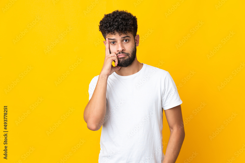 Young Moroccan man isolated on yellow background thinking an idea Young Moroccan man isolated on yellow background thinking an idea