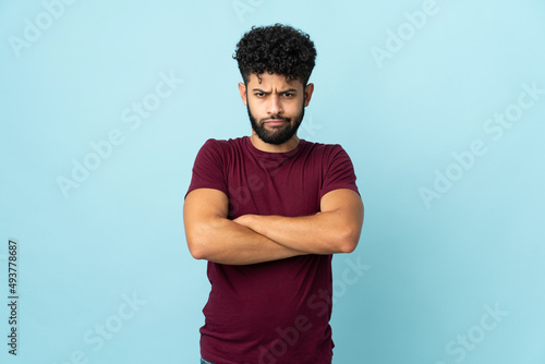 Young Moroccan man isolated on blue background with unhappy expression