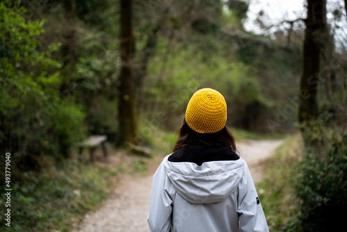 Person with a yellow beanie walking in the forest