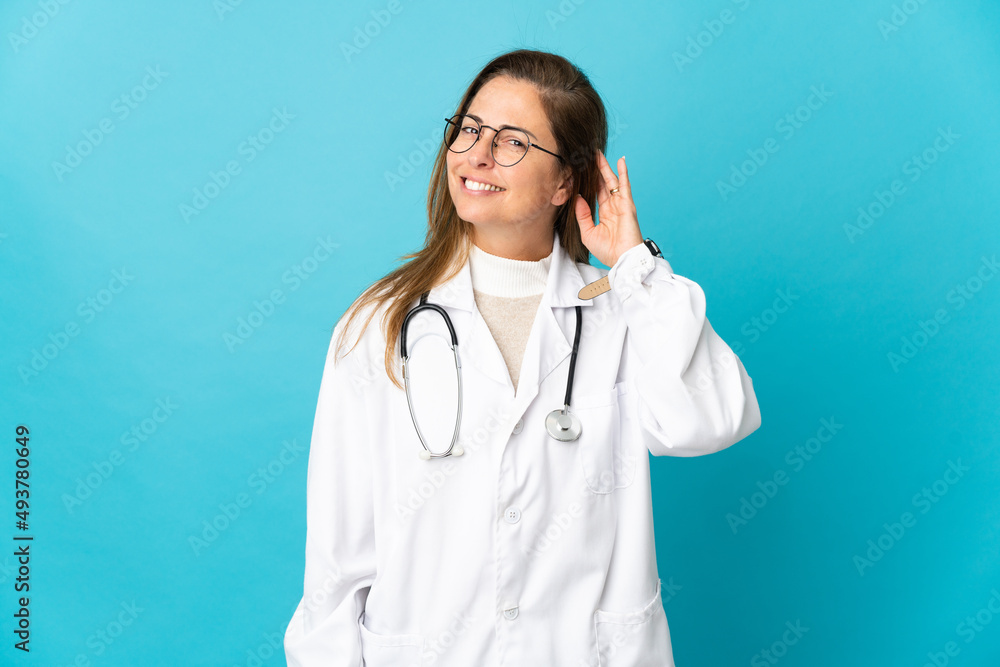 Middle age Brazilian doctor woman isolated on blue background having doubts