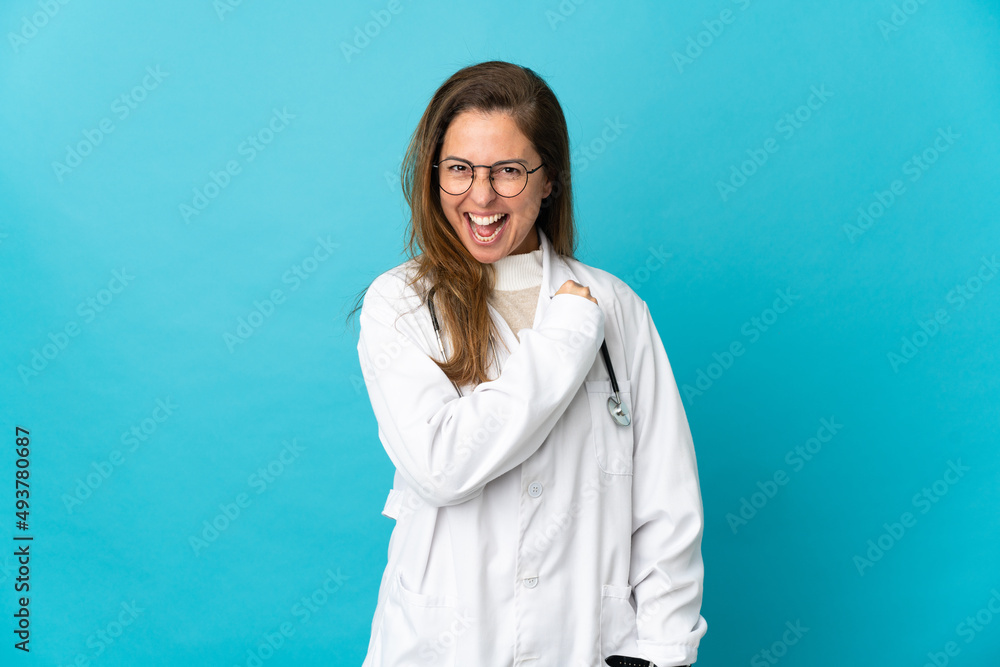 Middle age Brazilian doctor woman isolated on blue background celebrating a victory Middle age Brazilian doctor woman isolated on blue background celebrating a victory