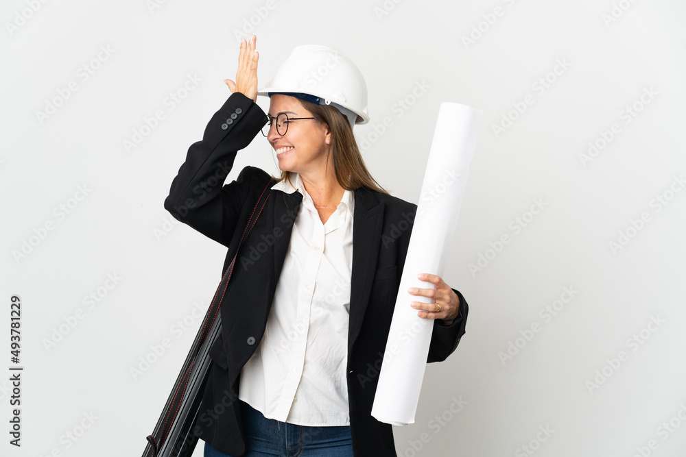 Middle age architect woman with helmet and holding blueprints over isolated background has realized something and intending the solution Middle age architect woman with helmet and holding blueprints over isolated background has realized something and intending the solution