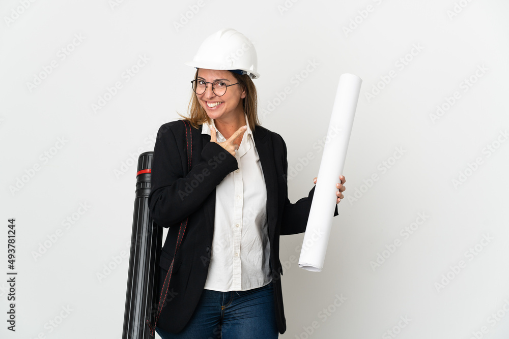 Middle age architect woman with helmet and holding blueprints over isolated background happy and smiling Middle age architect woman with helmet and holding blueprints over isolated background happy and smiling