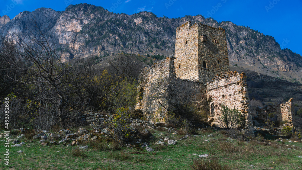 An abandoned medieval town. Military and residential ancient towers built of stones. Landscape in the mountains with a view of the ruins. An ancient city in the mountains.
