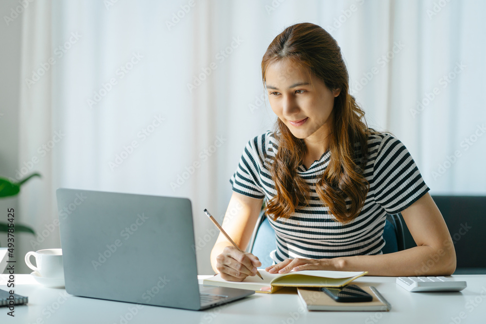 Asian business woman working with laptop or learning online at home in living room. Asian business woman working with laptop or learning online at home in living room.