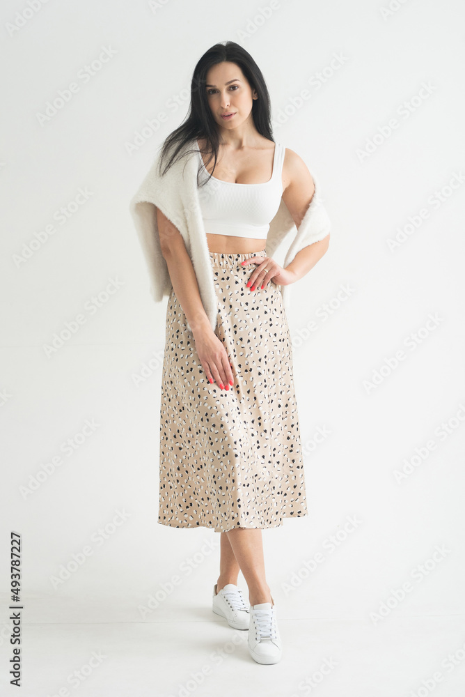 adult slender brunette girl model with a silk skirt and top on a white background adult slender brunette girl model with a silk skirt and top on a white background