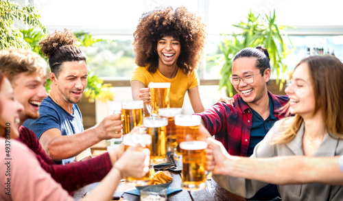 Young trendy people drinking and toasting beer at brewery bar restaurant - Beverage life style concept with guy and girls having fun together outdoors - Bright vivid filter with focus on mid woman