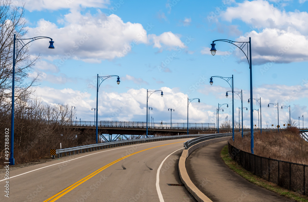 A streetlamp lined road leading to the Rankin Bridge in Rankin, Pennsylvania, USA on a sunny winter day