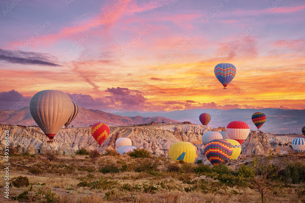 Travel and tourism by Turkey. Famous sightseeing Cappadocia, Anatolia.  Beautiful landscape with mountains, caves and baloons in the sky. Stock  Photo | Adobe Stock