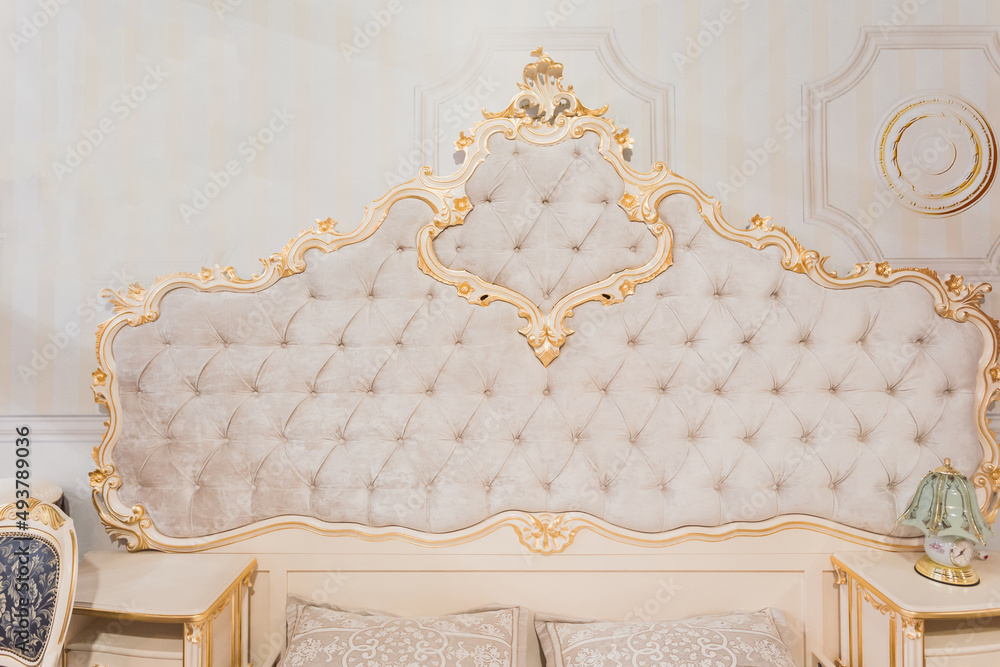 Luxury royal headboard of expensive bed with golden elements and light  beige textile - elegant part of bedroom interior Stock Photo | Adobe Stock