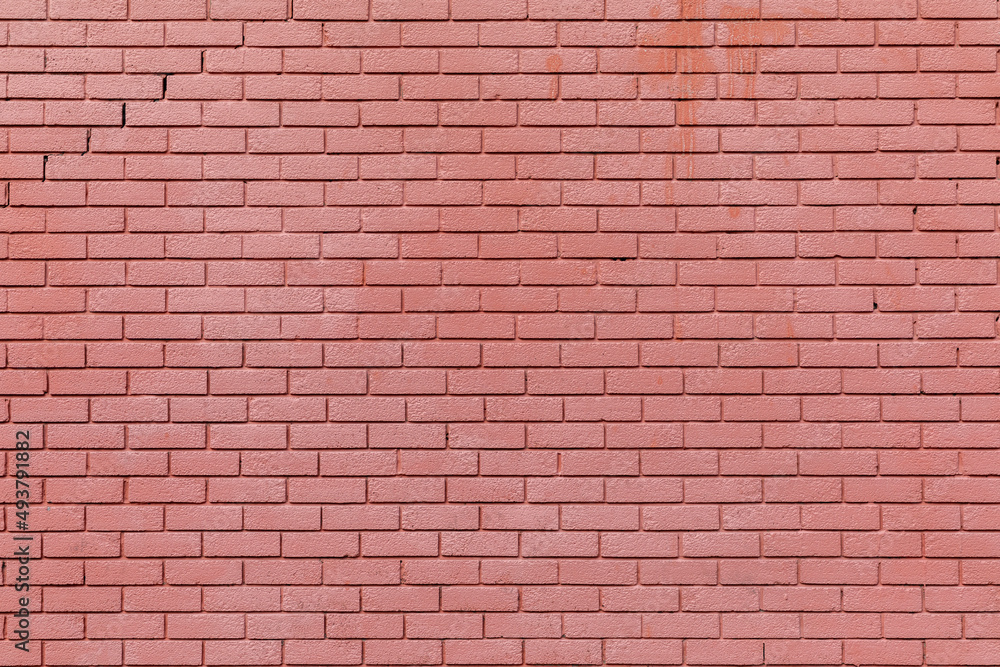 Obraz premium A brick wall painted with red paint, background texture