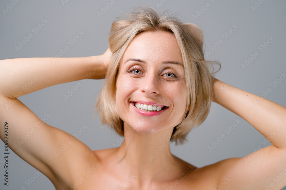 Natural beauty. Blonde woman with healthy skin. No makeup. Grey background. Natural beauty. Blonde woman with healthy skin. No makeup. Grey background.
