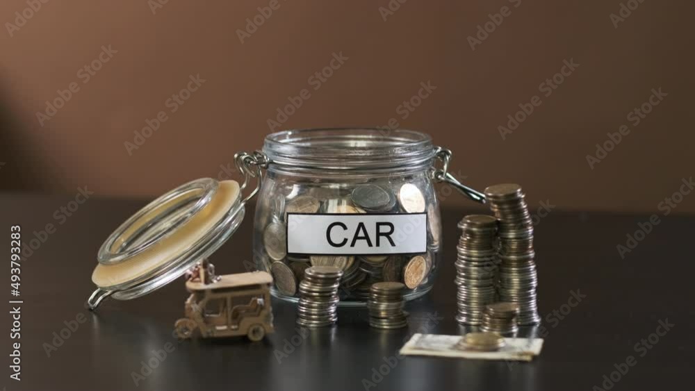 Hand of Man Puts Coin into a Glass with Inscription Car. Savings, Investment and Personal Finance Management Concept Hand of Man Puts Coin into a Glass with Inscription Car. Savings, Investment and Personal Finance Management Concept
